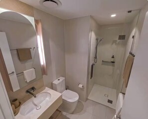 Une salle de bain moderne équipée d’un lavabo, de toilettes et d’une douche.