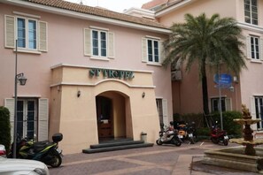 Un edificio con un letrero que dice 'ST TROPEZ' y una palmera en primer plano.