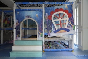 A children's play area with a slide, netted play structures, and a colorful mural. - Seven Seas Cote d'Azur One-bedroom near Beach (Pattaya)