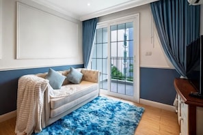A room with a sofa, a blue furry rug, and a sliding glass door. - Seven Seas Cote d'Azur One-bedroom near Beach (Pattaya)