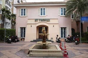 A building with a fountain in front, a sign reading 'ST. THOMAS,' and a palm tree to the right.
