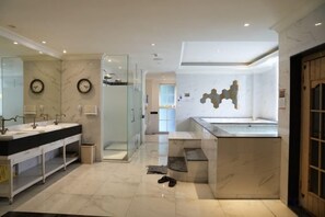 A modern bathroom with a glass shower enclosure, a double sink vanity, and a marble countertop.