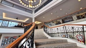 A multi-level interior with a central staircase, decorative lighting, and a ceiling with a circular light fixture. - PD Admiral Cove Private Unit - Up to 4 Pax (Port Dickson)