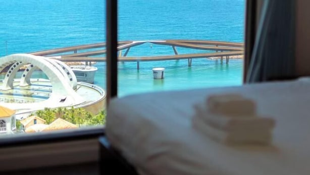 A room with a view of a water body and a circular structure.