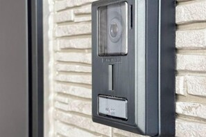 A wall-mounted intercom system with a keypad and a speaker grille. - louis stage ikebukurohoncho (Tokyo)