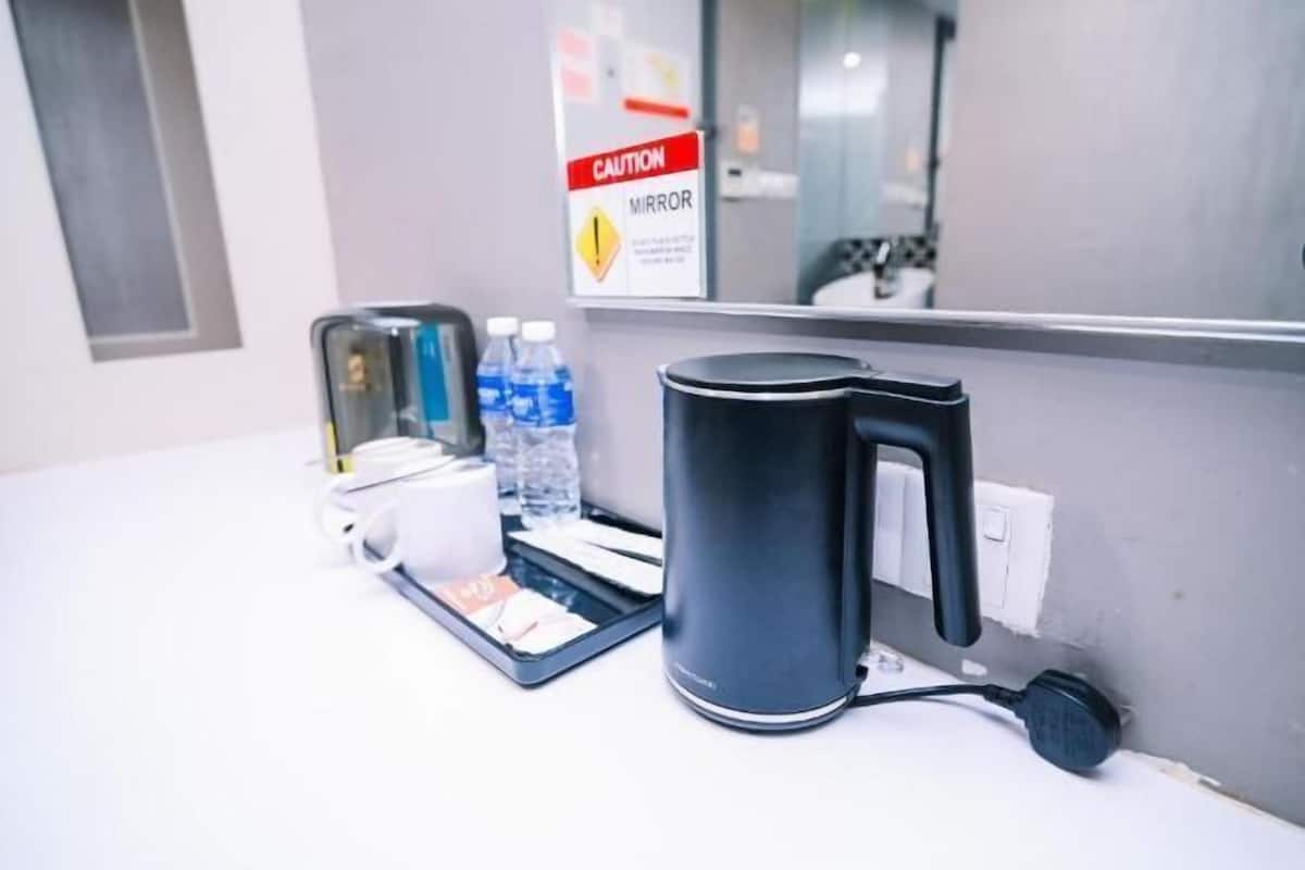 Ein Hotelzimmer mit Kaffeemaschine, Tablett mit Pflegeprodukten und Warnhinweis für den Spiegel.