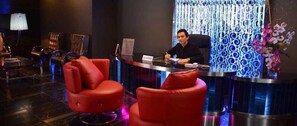 Un espace d’accueil comprenant un comptoir, des chaises et un rideau décoratif.