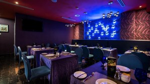 A restaurant with tables set for dining, chairs, and a decorative wall with blue lighting. - Kingston Hotel 3 @ Kuala Lumpur (Kuala Lumpur)