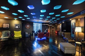 Eine Hotellobby mit Empfangstresen, Sitzgelegenheiten und einer Wand mit Muster.