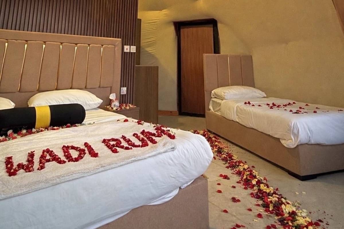 A bedroom with a unique textured ceiling, a bed with rose petals, and an air conditioning unit.