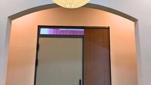 A modern interior with a curved ceiling, a sliding glass door, and a wooden slat wall. - LYLAC Home Saigon TDX - City Center Cosy 4BR Townhouse with Garden in D1 (Ho Chi Minh City)