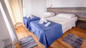 Ett hotellrum med två separata sängar, en träpanel vid sänggaveln och en liten matta på golvet.