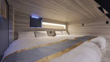 A modern bedroom with a large bed, a flat-screen TV mounted on the wall, and a unique wooden ceiling design.