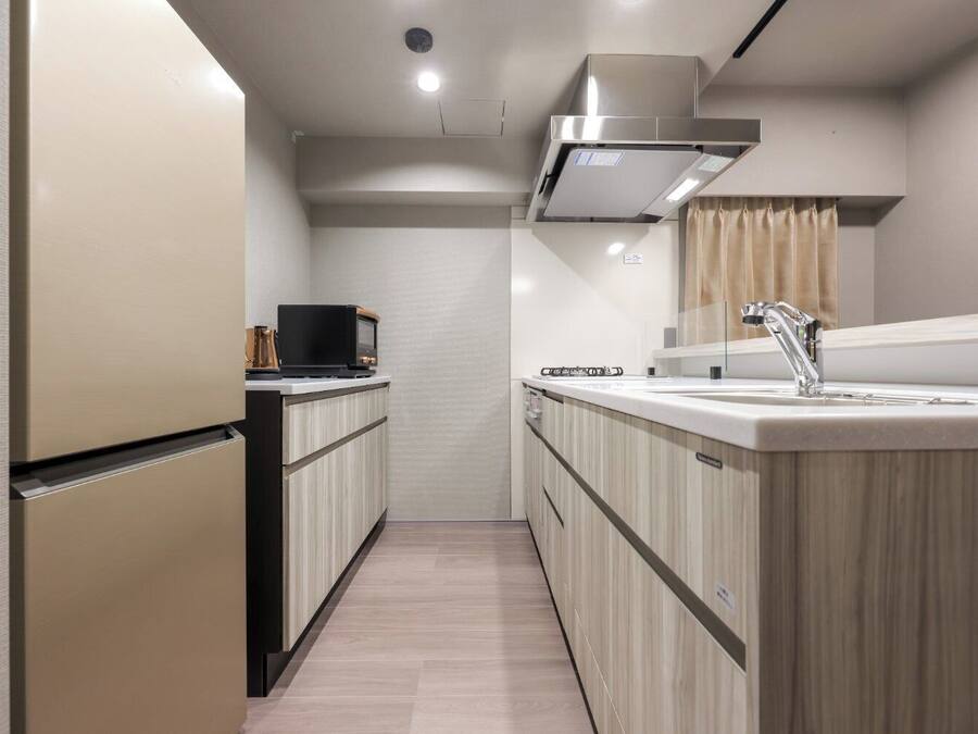 A compact kitchen with a refrigerator, microwave, stove, and sink.