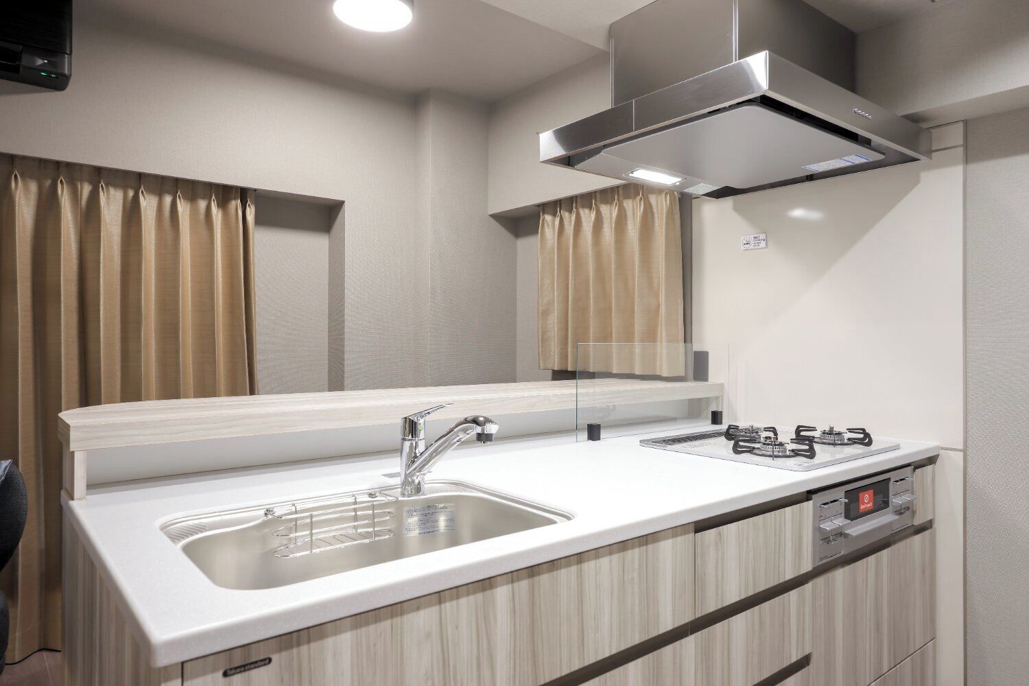 A modern kitchen with a stainless steel sink, a gas stove, and a built-in oven.