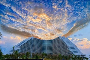 A modern hotel with a unique curved architecture, surrounded by greenery. - Sun SeaView Cam Ranh Resort (Cam Ranh)