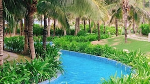 A swimming pool surrounded by lush greenery and palm trees. - Sun SeaView Cam Ranh Resort (Cam Ranh)