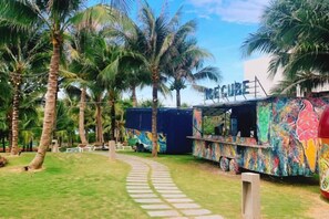 A colorful bus converted into a mobile restaurant with a pathway leading to it. - Sun SeaView Cam Ranh Resort (Cam Ranh)