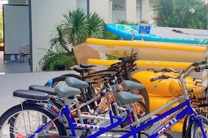 A bicycle parked in front of a building with a yellow inflatable structure and a blue kayak in the background. - Sun SeaView Cam Ranh Resort (Cam Ranh)
