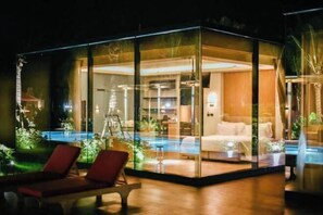 A modern glass-enclosed room with a pool, lounge chairs, and a visible kitchen area. - Mirror Mirror Hotel Cafe & Restaurant (Klaeng)