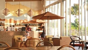 A restaurant with large windows, wooden ceiling, and hanging pendant lights. - Mirror Mirror Hotel Cafe & Restaurant (Klaeng)