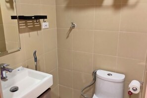 Un bagno con lavandino, specchio, WC e doccia.