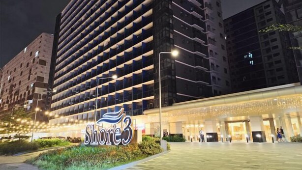 A hotel with a modern facade, a prominent 'Shore3' sign, and a spacious entrance area. - Callie's Cozy Staycation (Pasay)
