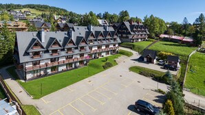 Un hotel a più piani con un parcheggio e un piccolo edificio adiacente.