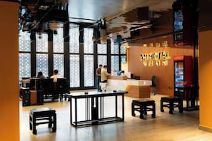 A modern hotel lobby with a reception desk, seating area, and large windows. - AN HOTEL (Bac Ninh)