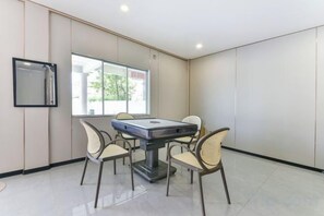 A conference room with a table and chairs, a large window, and a wall-mounted TV. - Anaya Villa Resort (Semporna)