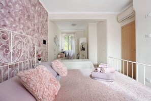 Quarto com cama, mesa de cabeceira, espelho e porta.