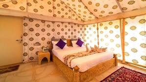 A room with a bed, a nightstand, and a window with patterned curtains. - Jodhani Desert Camp & Resort Jaisalmer (Jaisalmer)
