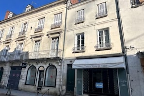 Un edifici amb nombroses finestres, una botiga amb un cartell i una porta amb un rètol.