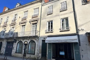 A building with multiple stories, featuring arched windows and balconies.