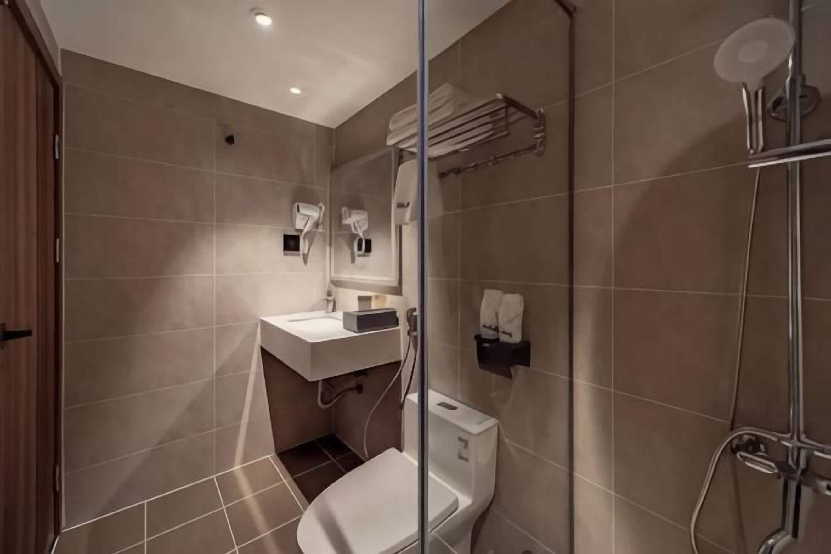 Un baño moderno con inodoro, lavabo y ducha.