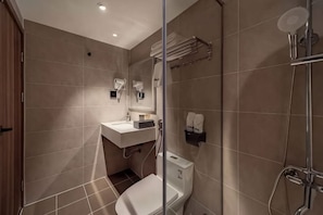 Un baño moderno con inodoro, lavabo y ducha.