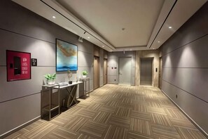 Un pasillo de hotel de diseño moderno, con piso estampado, una recepción y un cuadro en la pared.