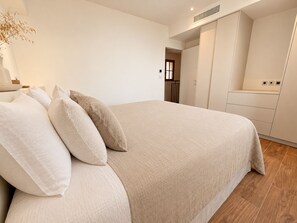 A bedroom with a bed, pillows, a nightstand, and a wardrobe. - Villa Lunassina (Cargèse)