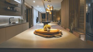 A modern kitchen with a central island, stainless steel appliances, and a contemporary light fixture.
