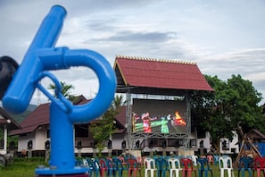 A building with a red roof and a stage for performances. - Hometown of Dragon Hotel (Vang Vieng)