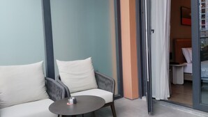 A modern room with a sofa, a small round table, and a sliding glass door leading to a bedroom. - Chongqing Justom Family Apartment Hotel (Chongqing)