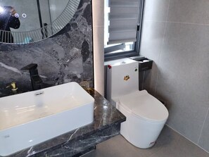 A bathroom with a marble sink, a toilet, and a mirror. - Chongqing Justom Family Apartment Hotel (Chongqing)