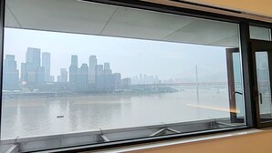 A view of a city skyline with high-rise buildings and a bridge across a river. - Chongqing Justom Family Apartment Hotel (Chongqing)
