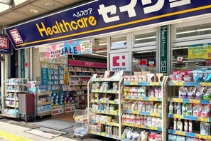 Una farmacia con un letrero llamativo que dice 'Healthcare', estantes repletos de diversos productos y un anuncio de rebajas.