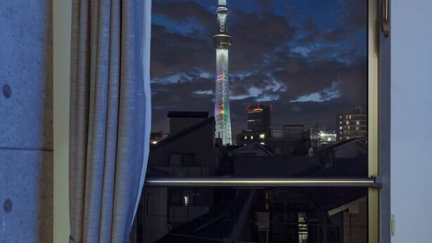 A view of a tower with a cable structure, a staircase, and surrounding buildings. - Tokyo Sakura Hotel (Tokyo)
