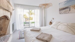 Un dormitorio con cama, vistas al exterior, chimenea y un cuadro en la pared.