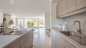 Una cocina moderna con una isla grande, armarios empotrados y vistas al exterior.