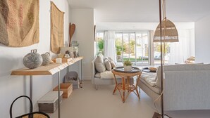 Una sala moderna con un sofá, una mesa redonda y una lámpara colgante.