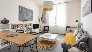 Ein modernes Wohnzimmer mit Esstisch, Sofa und einer großen Wandkarte.