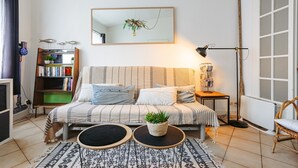 Une chambre confortable avec un lit, des tables de chevet, une bibliothèque, un miroir et une fenêtre.